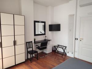 Zimmer mit einem Spiegel, 2 Stühlen und einem Schreibtisch in der Unterkunft Tre R in Rom