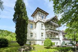 ein großes weißes Haus mit einem Turm in der Unterkunft Solehotel Winterberg in Bad Harzburg