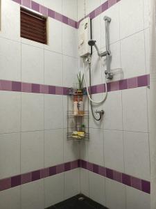 y baño con ducha de azulejos morados y blancos. en บาคัสโฮมลอร์ด en Haad Chao Samran