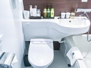 a bathroom with a white toilet and a sink at HOTEL LiVEMAX Meieki in Nagoya