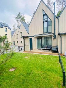 a house with a green lawn in front of it at Sun&Sea in Palanga