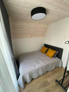 a bedroom with a bed with yellow pillows at Sun&Sea in Palanga