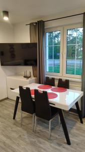 uma sala de jantar com uma mesa branca e cadeiras em Apartamenty wakacyjne em Ślesin