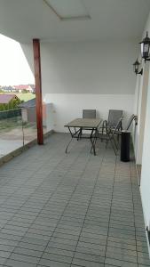 um pátio com uma mesa e cadeiras em Apartamenty wakacyjne em Ślesin