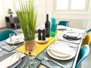 uma mesa de jantar com pratos e garrafas de vinho em The 5 continents III by Stay Swiss em Porrentruy