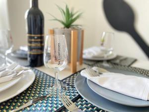 uma mesa com copos e pratos de vinho e uma garrafa de vinho em The 5 continents III by Stay Swiss em Porrentruy