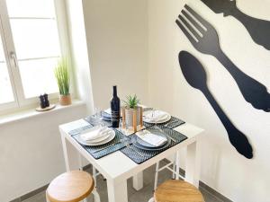 a white table with plates and a bottle of wine at The 5 continents III by Stay Swiss in Porrentruy