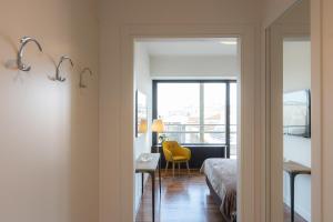 a bedroom with a bed and a desk with a yellow chair at Amazing Via Parigi in Rome