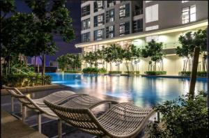 a swimming pool with two chairs in front of a building at The Robertson Bukit Bintang Luxe Suites in Kuala Lumpur