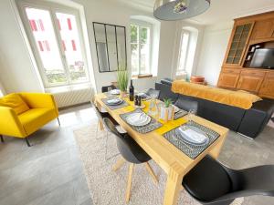 een woonkamer met een houten tafel en stoelen bij The 5 Continents II by Stay Swiss in Porrentruy