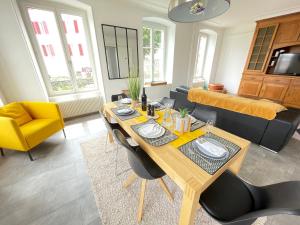 uma sala de estar com uma mesa de madeira e cadeiras em The 5 Continents II by Stay Swiss em Porrentruy