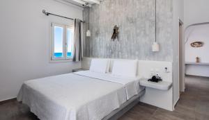 biała sypialnia z łóżkiem i umywalką w obiekcie Tania Milos w mieście Pollonia