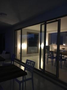 une salle à manger avec des chaises et une table. dans l'établissement Luxury villa Blue&Blanc piscina a sfioro isola, à Diamante