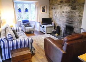a living room with couches and a stone fireplace at Bar Hill Lodge in Gatehouse of Fleet