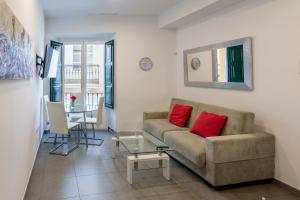 a living room with a couch and a table at Reservaloen Terrazas de la Catedral in Seville
