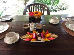 una mesa de madera con un plato de comida. en Rumah Kelapa Sepi en Karangasem