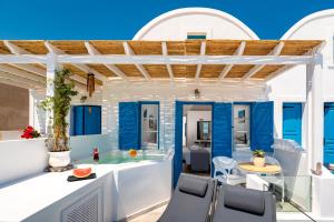 a villa with a swimming pool and blue ceilings at Seaside Breeze in Kamari