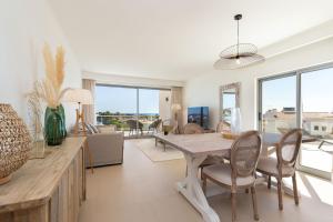 een eetkamer en een woonkamer met een tafel en stoelen bij Varandas do Castelo By Garvetur in Albufeira