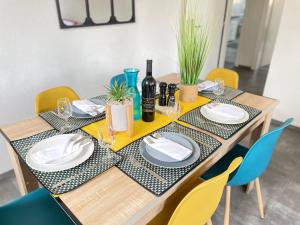 uma mesa de jantar com pratos e garrafas de vinho em The 5 Continents - All 3 floors by Stay Swiss em Porrentruy
