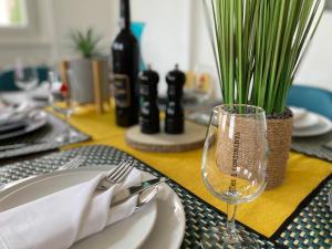 uma mesa com um prato e garfo e um copo de vinho em The 5 Continents - All 3 floors by Stay Swiss em Porrentruy