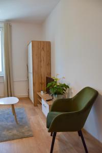 uma sala de estar com uma cadeira verde e um frigorífico em Nest Centrum Konin em Konin