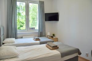 two twin beds in a room with a window at Nest Centrum Konin in Konin