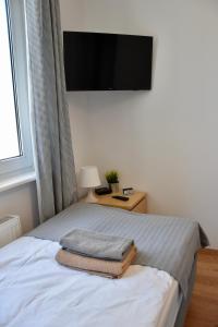 a bedroom with a bed with a television on the wall at Nest Centrum Konin in Konin