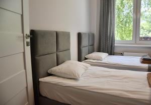 two twin beds in a room with a window at Nest Centrum Konin in Konin