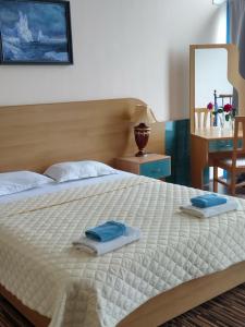 - une chambre avec un grand lit et des serviettes dans l'établissement Hotel Iceberg, à Balchik