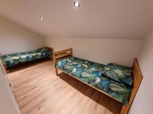 two beds in a room with wooden floors at Susberg 4 in Pelt +22 photos