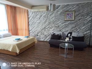 ein Schlafzimmer mit einem Bett und einem Sofa in der Unterkunft Hotel Iceberg in Baltschik