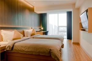 a bedroom with two beds and a television in it at MIllennium Plaza Hotel & Mall Ulaanbaatar in Ulaanbaatar +66 photos
