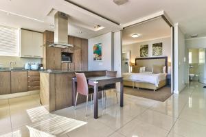 una cucina con tavolo e un letto in una camera di The Crystal Apartments a Città del Capo