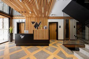an office lobby with a reception desk and wooden ceilings at Wrota Chałubińskiego in Zakopane