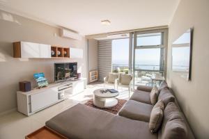 un soggiorno con divano e TV di The Crystal Apartments a Città del Capo