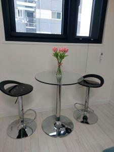 un tavolo di vetro con un vaso di fiori sopra di Xeromine Hostel Dongdaemun a Seul