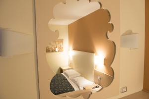 a mirror on a wall with a bed in a room at Hotel Duca Degli Abruzzi in Montesilvano +16 photos