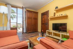 un soggiorno con mobili arancioni e TV a schermo piatto di Villa El Terreno a Palma de Mallorca