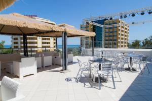 a patio with chairs and tables and umbrellas at Hotel Duca Degli Abruzzi in Montesilvano