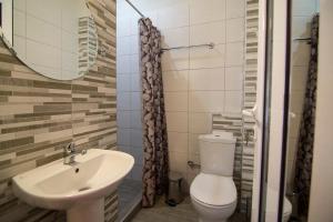 a bathroom with a sink and a toilet and a mirror at Christodoulos Eleftheria House in Nea Vrasna
