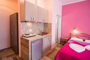 a kitchen with a pink room with a bed and a sink at Christodoulos Eleftheria House in Nea Vrasna +41 photos