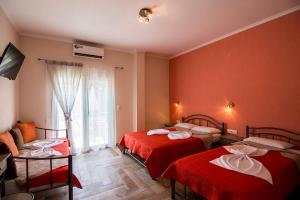 a hotel room with two beds and a window at Christodoulos Eleftheria House in Nea Vrasna