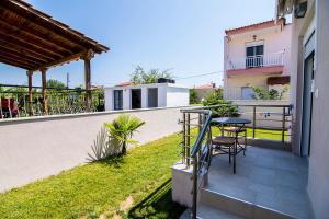 a patio with a table and chairs on a balcony at Christodoulos Eleftheria House in Nea Vrasna