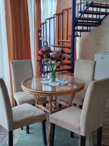 une table avec des chaises et un vase de fleurs. dans l'établissement Hotel Iceberg, à Balchik