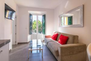 sala de estar con sofá y mesa de cristal en Reservaloen Terrazas de la Catedral en Sevilla