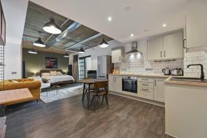 a kitchen and living room with a bed and a table at Modern and Chic Apartments at Ferrum near Wembley Park in London