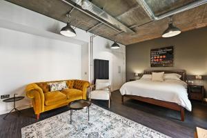 a bedroom with a bed and a couch and a chair at Modern and Chic Apartments at Ferrum near Wembley Park in London