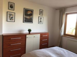 a bedroom with a bed and a dresser and a window at Apartmán 316 in Donovaly