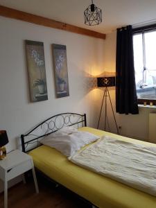 a bedroom with a bed and a lamp and a window at Pension Werner Nagel in Wewelsfleth