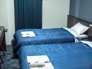 Łóżko lub łóżka w pokoju w obiekcie HOTEL LiVEMAX BUDGET Nagoya Taikodori